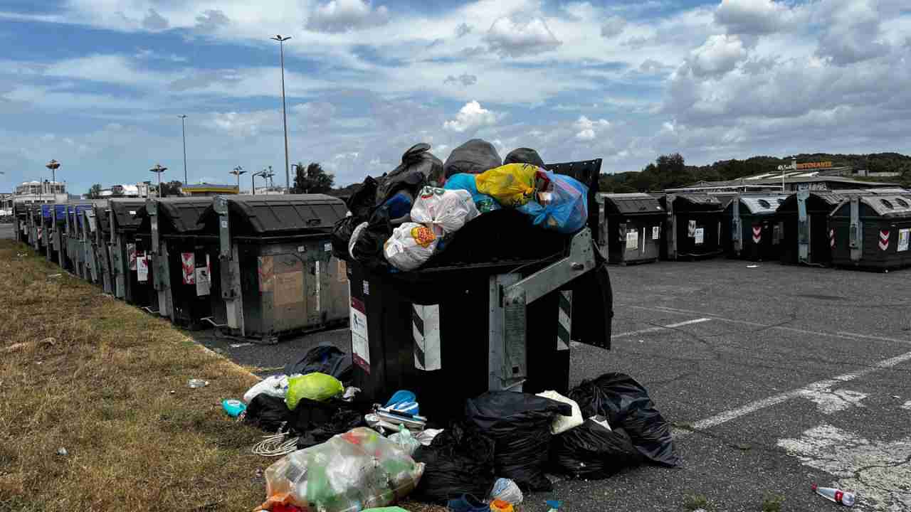 Contenitori pieni di rifiuti all'isola dei cassonetti Ama a Ostia