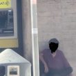 Clochard sdraiato ai piedi dell'ATM della Posta Centrale di Ostia