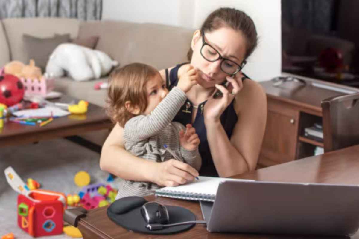 Mamma lavora tenendo in braccio la figlia piccola